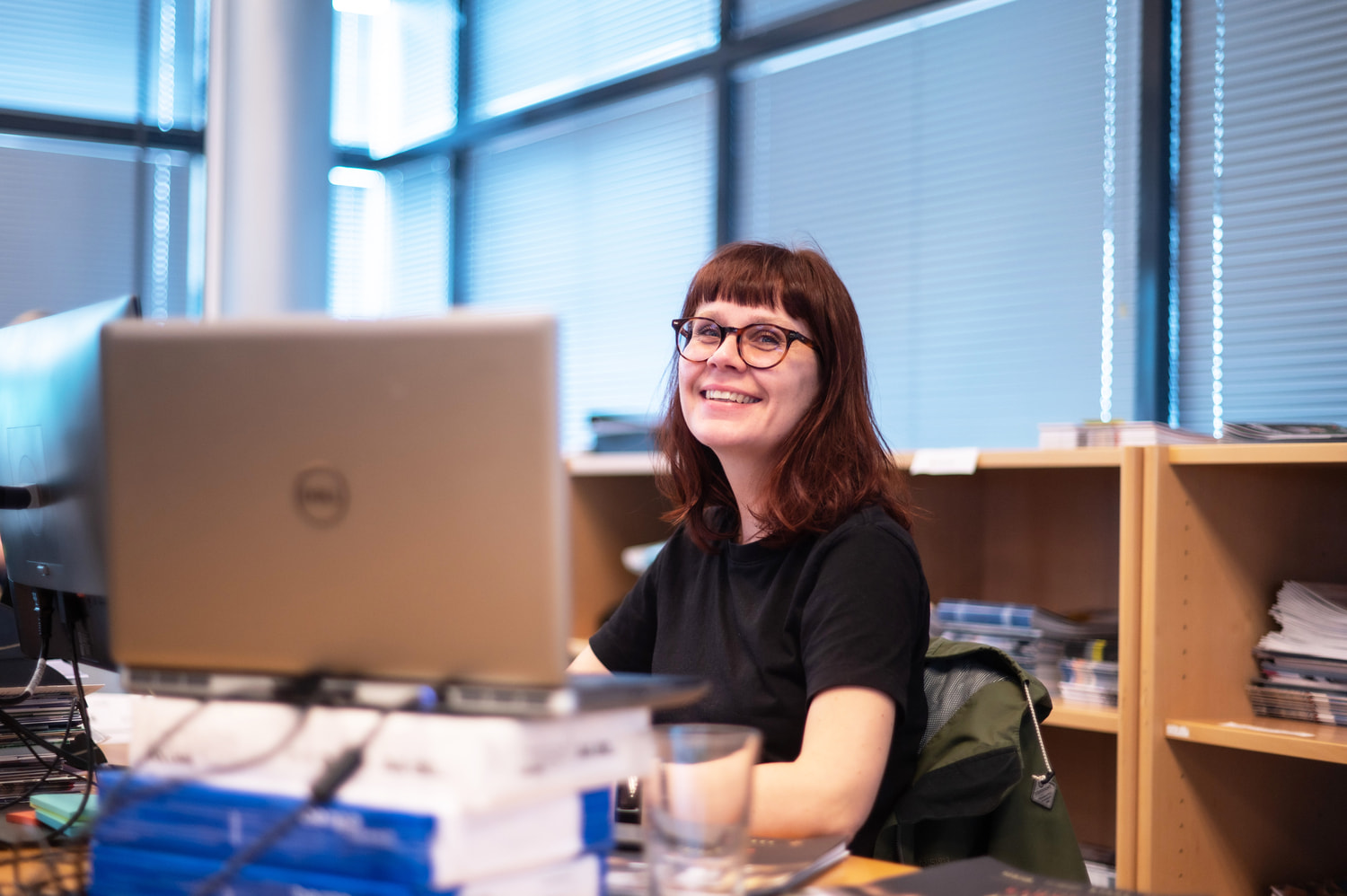 A smiling woman sitting in front of a computer.